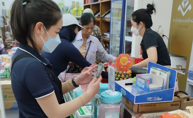 Người dân quẹt thẻ tại quầy thanh toán khi mua sắm hàng hóa tại một cửa hàng ở phường Yên Ninh, thành phố Yên Bái. 
